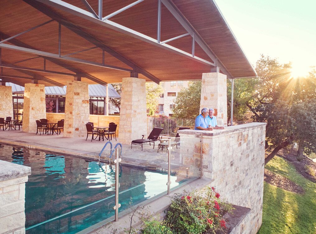 elevated and covered outdoor lap pool and lounge at Querencia Senior Living Community in Austin, TX