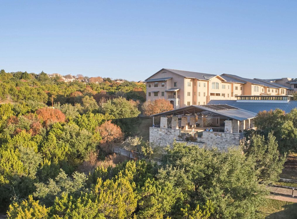 elevated view of Querencia Senior Living Community tucked into the surrounding lush, hilled landscape