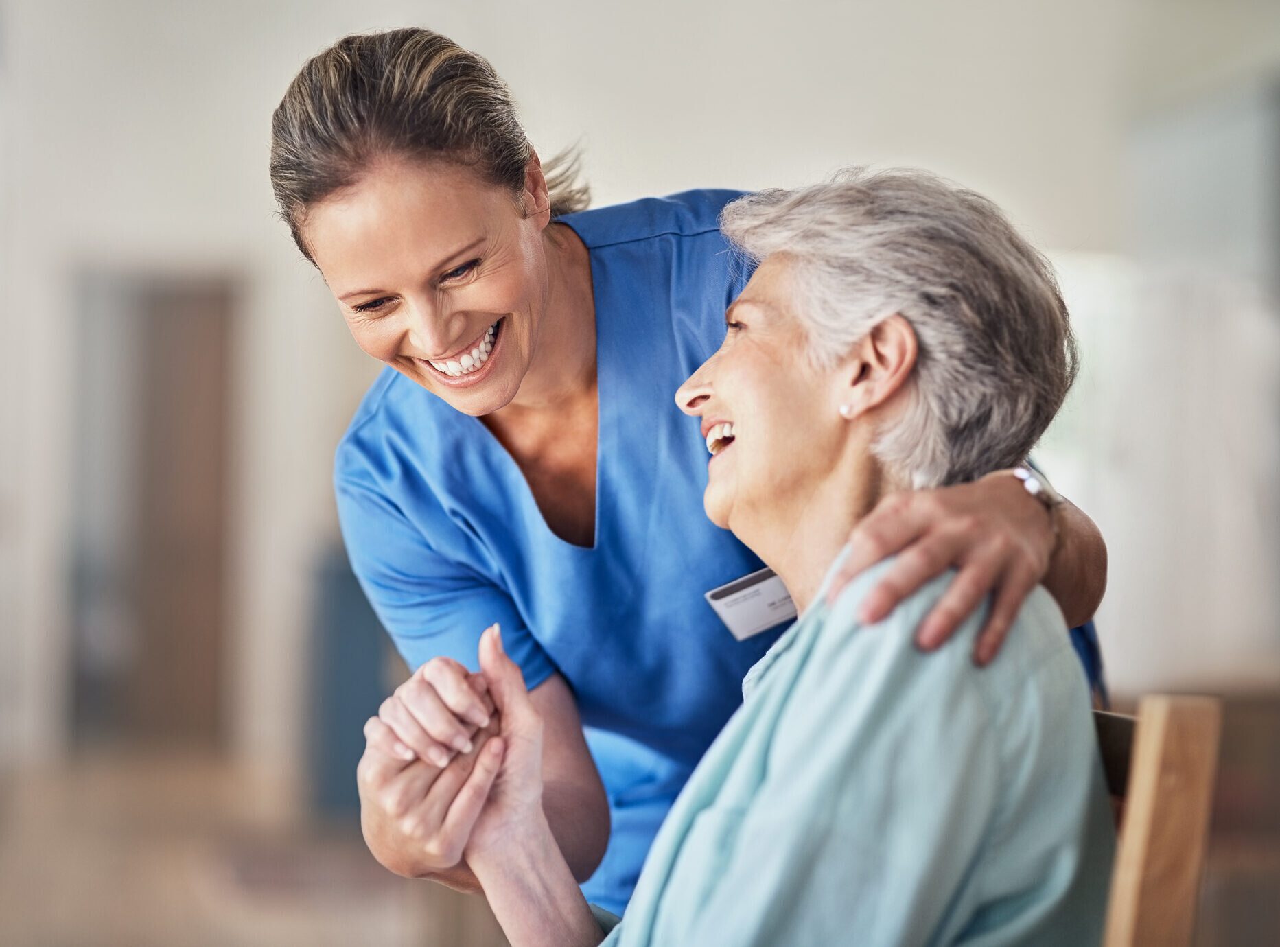 Senior woman laughing with nurse