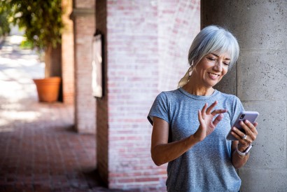 senior woman listening to music while she looks at her smart phone