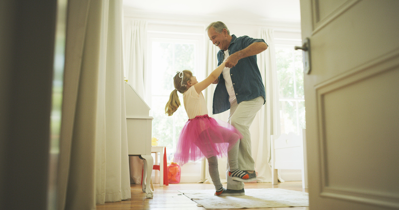 a senior man dancing with his granddaughter
