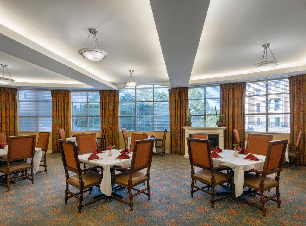 upscale dining area with multiple tables at Querencia's Assisted Living building