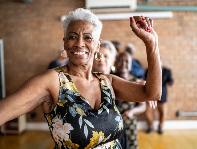 Senior woman dancing happily in a fitness class.
