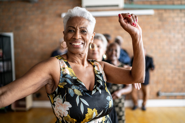 Senior woman dancing happily in a fitness class.